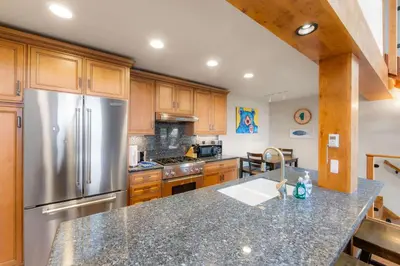 a kitchen with wooden cabinets and a stainless steel refrigerator at Aspen Edge Lakefront and Loft in South Lake Tahoe