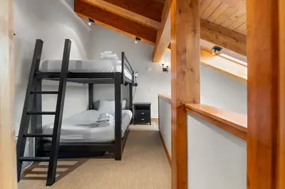 a bunk bed room with two bunk beds and a staircase at Aspen Edge Lakefront and Loft in South Lake Tahoe