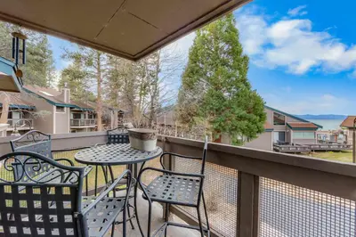 a patio with a table and chairs on a balcony at Aspen Edge Lakefront and Loft in South Lake Tahoe