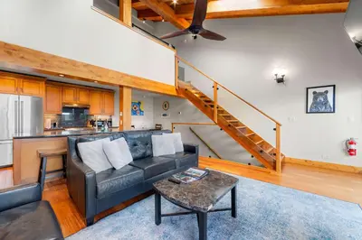 a living room with a couch and a staircase at Aspen Edge Lakefront and Loft in South Lake Tahoe