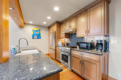 a kitchen with wooden cabinets and granite counter tops at Aspen Edge Lakefront and Loft in South Lake Tahoe