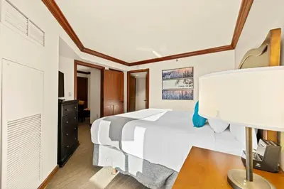 a bedroom with a bed and a desk with a lamp at 6th Floor Fireplace Suite in Tahoe City