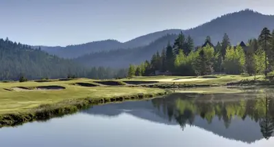 a golf course with a lake and mountains in the background at 6th Floor Fireplace Suite in Tahoe City