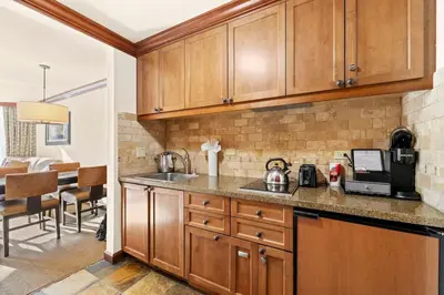a kitchen with wooden cabinets and a counter top at 6th Floor Mountain View Room - Fireplace Suite in Tahoe City