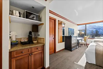 a hotel room with a bed and a kitchen and a bedroom at 6th Floor Mountain View Room - Fireplace Suite in Tahoe City