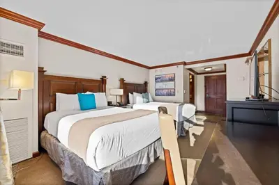 a hotel room with two beds and a television at 6th Floor Mountain View Room - Fireplace Suite in Tahoe City