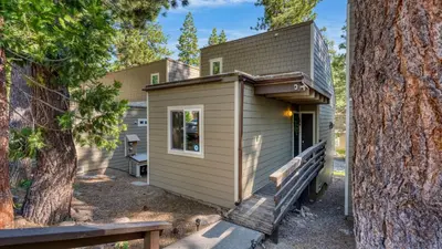 a tiny house with a porch next to a tree at Cozy Tahoe Townhome w Fireplace Balcony Quick Access to Trails Lake Cubana - Dollar Hill by AvantStay in Tahoe City