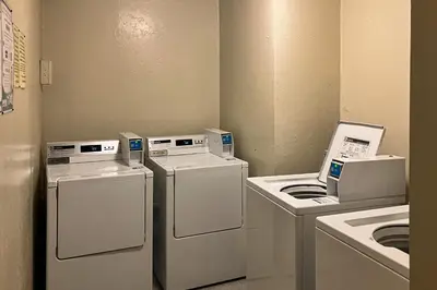 a laundry room with three machines and a washer and dryer at Summit 65 in Mammoth Lakes