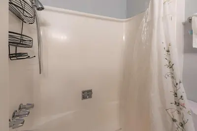 a bathroom with a white tub and a shower curtain at The Ale Arths Retreat for 8 in South Lake Tahoe