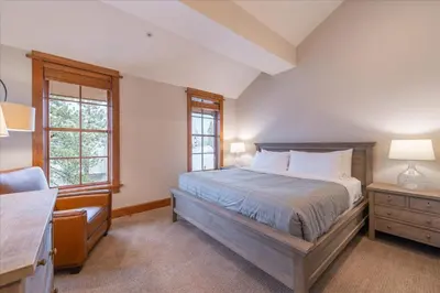 a bedroom with a bed and a desk and two windows at Ironhorse Northstar Condo condo in Truckee