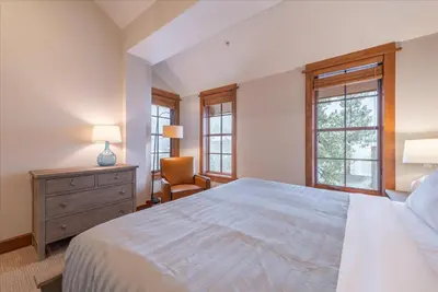 a bedroom with a bed and a chair and windows at Ironhorse Northstar Condo condo in Truckee