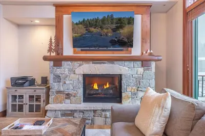 a living room with a fireplace with a tv above it at Ironhorse Northstar Condo condo in Truckee
