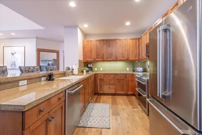 a kitchen with wooden cabinets and a stainless steel refrigerator at Ironhorse Northstar Condo condo in Truckee
