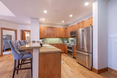 a kitchen with wooden cabinets and a stainless steel refrigerator at Ironhorse Northstar Condo condo in Truckee