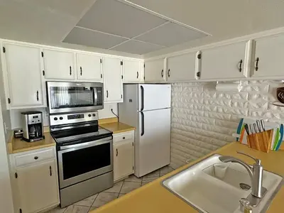 a kitchen with white cabinets and a stove and refrigerator at 439 Ala Wai, 119 condo in South Lake Tahoe