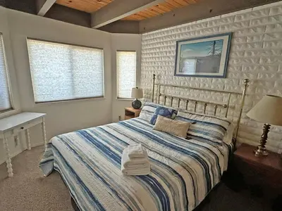 a bedroom with a bed with a blue and white comforter at 439 Ala Wai, 119 condo in South Lake Tahoe