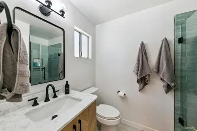 a bathroom with a sink and a toilet and a mirror at 3300 Cape Horn home in South Lake Tahoe