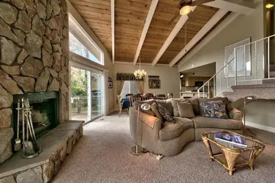 a large living room with a stone fireplace at 1673 Venice Drive home in South Lake Tahoe