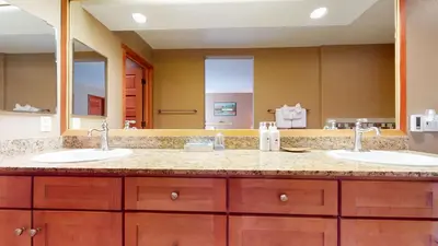 a bathroom with two sinks and a large mirror at Snowcreek V #1002 condo in Mammoth Lakes