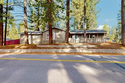 a house in the woods with a road in front of it at Mid-Century Tahoe Ranch House in South Lake Tahoe