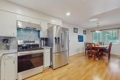 a kitchen with stainless steel appliances and a table with chairs at Mid-Century Tahoe Ranch House in South Lake Tahoe