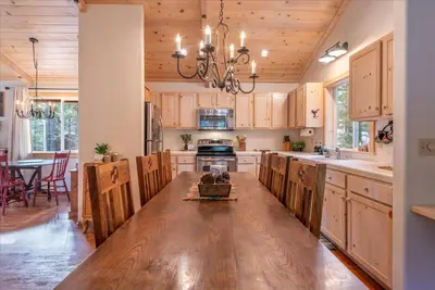 a kitchen with a wooden table and a dining room at Tahoe Pines Beach Retreat home in Homewood