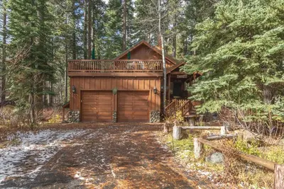 a log cabin in the woods with a driveway at Tahoe Pines Beach Retreat home in Homewood