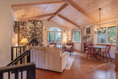 a living room with a stone wall at Tahoe Pines Beach Retreat home in Homewood