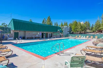 a large swimming pool with chairs and a building at WilderNest in Stateline