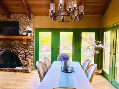 a dining room with a table and a fireplace at 2 Homes by the River in Three Rivers