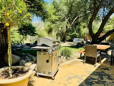 a grill in a garden with a table and a picnic table at 2 Homes by the River in Three Rivers