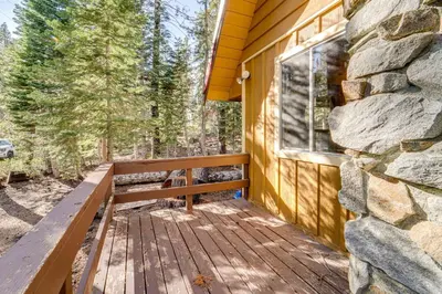 a wooden bench sitting on a porch next to a stone wall at Near Slopes, Donner Lake and Trails! Woodsy Retreat in Truckee