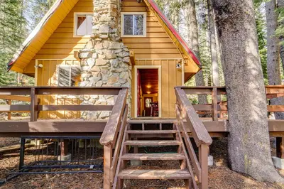 a cabin in the woods with a staircase leading up to it at Near Slopes, Donner Lake and Trails! Woodsy Retreat in Truckee