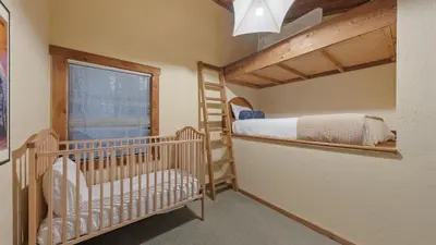a nursery with two bunk beds and a crib at Cozy Donner Lake Cabin w Kayaks Forest Views Fireplace Quick Ski Resort Access Donner Lake Refuge by AvantStay in Truckee