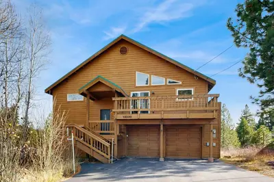 a log house with a deck and a garage at Hillside Chalet in Truckee
