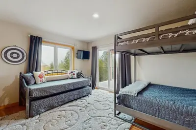 a bedroom with a bunk bed and a couch at Hillside Chalet in Truckee
