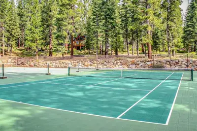 a tennis court with trees in the background at Kings Beach Luxe in Kings Beach