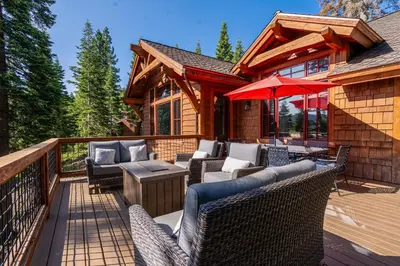 a deck with chairs and an umbrella on a cabin at Silverfox at Northstar in Truckee
