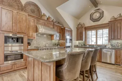 a kitchen with wooden cabinets and a island with bar stools at Silverfox at Northstar in Truckee