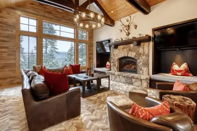 a living room with leather furniture and a stone fireplace at Silverfox at Northstar in Truckee
