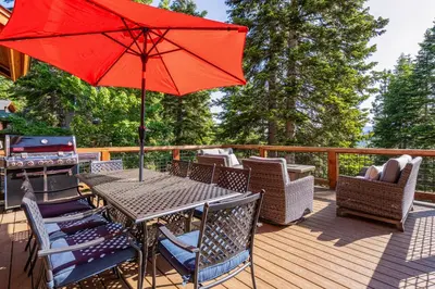 a table with a red umbrella on a deck at Silverfox at Northstar in Truckee
