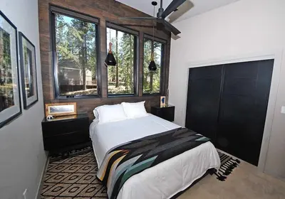 a bedroom with a large bed and some windows at 676 El Dorado Avenue home in South Lake Tahoe