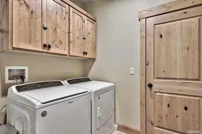 a white washing machine in a kitchen with wooden cabinets at 539 Wintoon Drive home in South Lake Tahoe