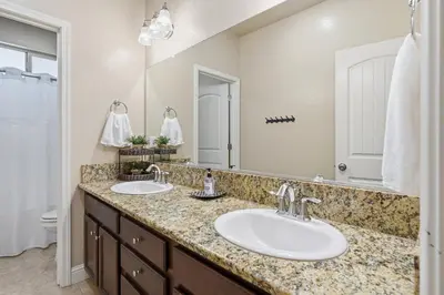 a bathroom with two sinks and a large mirror at Casa Cortez in Visalia