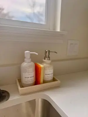 a bathroom sink with two bottles of soap on a holder at New! Modern 4BR max 12 ppl, 5 mins to everything! in Reno