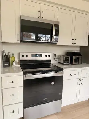 a kitchen with a black stove and a microwave at New! Modern 4BR max 12 ppl, 5 mins to everything! in Reno