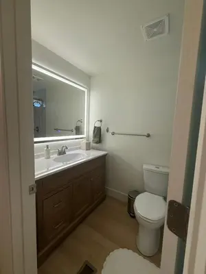 a bathroom with a sink and a toilet and a mirror at New! Modern 4BR max 12 ppl, 5 mins to everything! in Reno