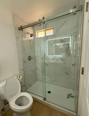 a bathroom with a glass shower with a toilet at New! Modern 4BR max 12 ppl, 5 mins to everything! in Reno