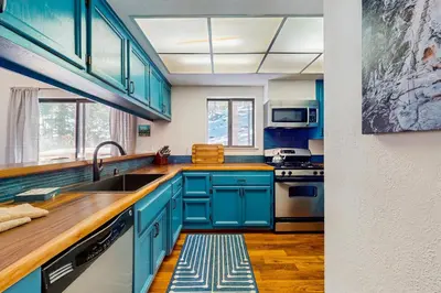 a kitchen with blue cabinets and a sink at Pine Hill Hideaway in South Lake Tahoe