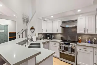 a kitchen with white cabinets and a stove top oven at Luxury 3BR 3BA Condo Steps from Canyon Lodge Lift in Mammoth Lakes
